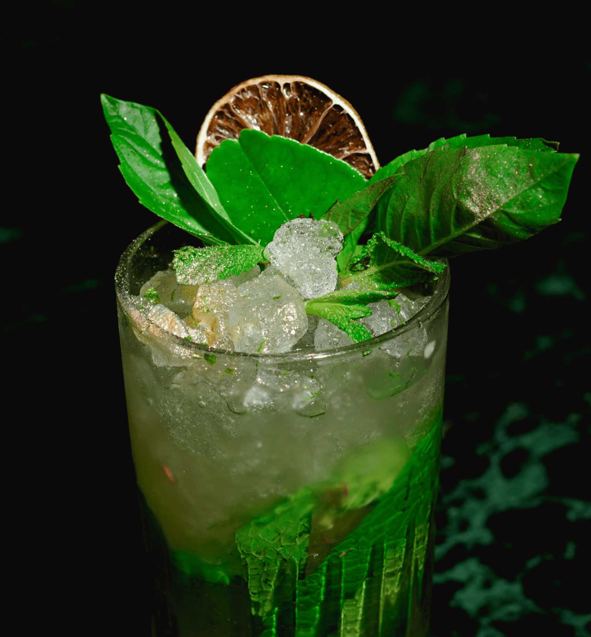 Green cocktail with leaves and ice